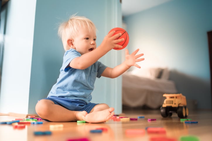 baby boy having fun at home playing with ball