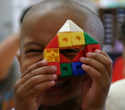 boy-looking-through-colorful-toy-with-one-eye