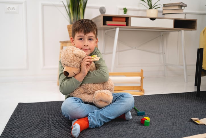 boy embracing teddy bear as a reward