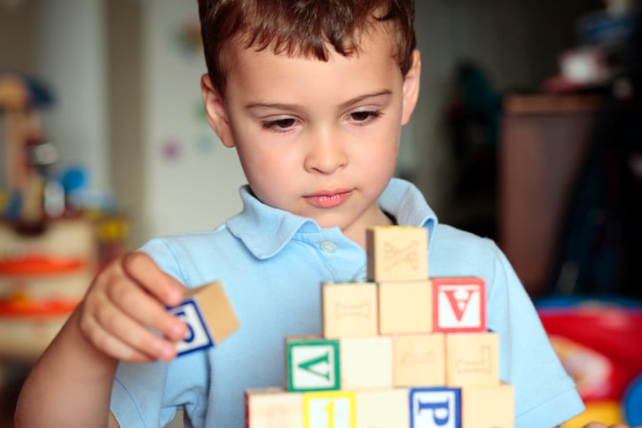 boy with autism playing with blocks