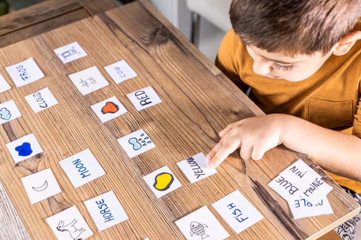 Boy with autism playing with cards of words and pictures