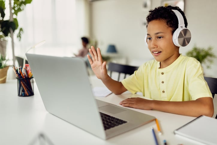 boy with autism raising hand in class on Zoom