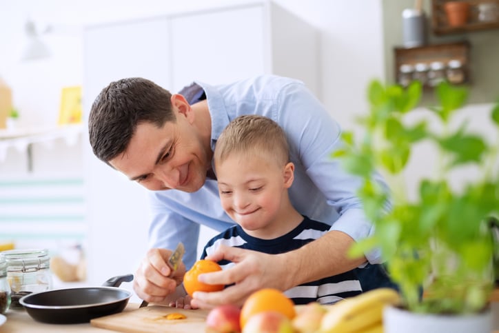boy with autism using knife with help from father
