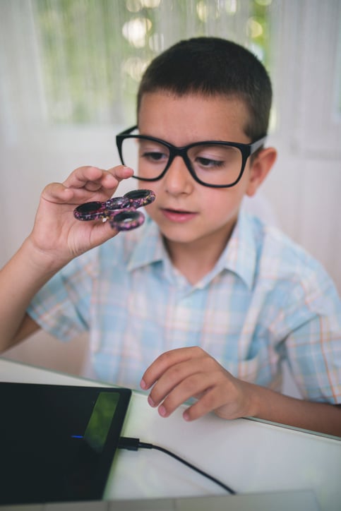 child with autism playing with fidget spinner