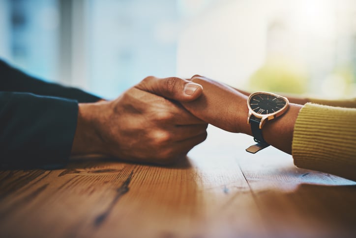couple-holding-hands-at-a-table