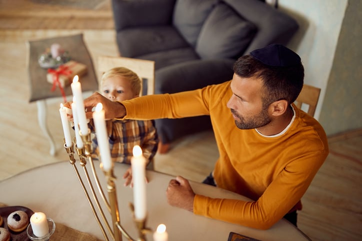 father and son with autism lighting menorah