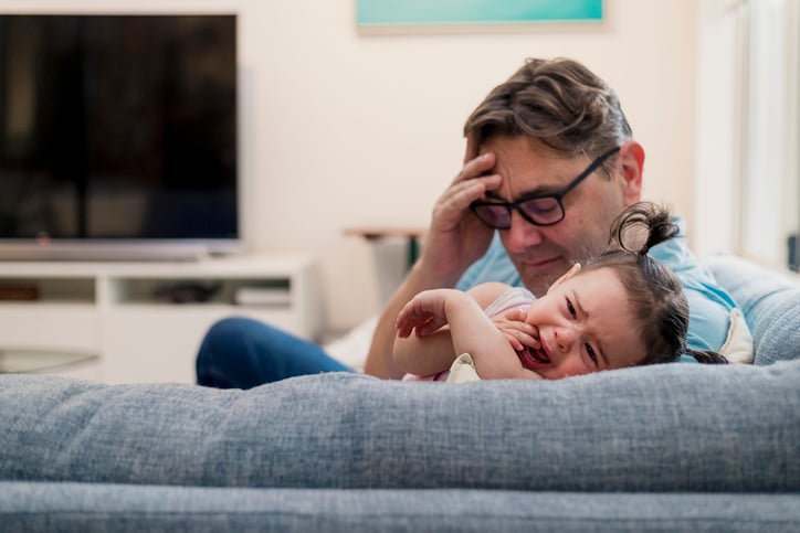 father looks in despair as his daughter with autism gets upset