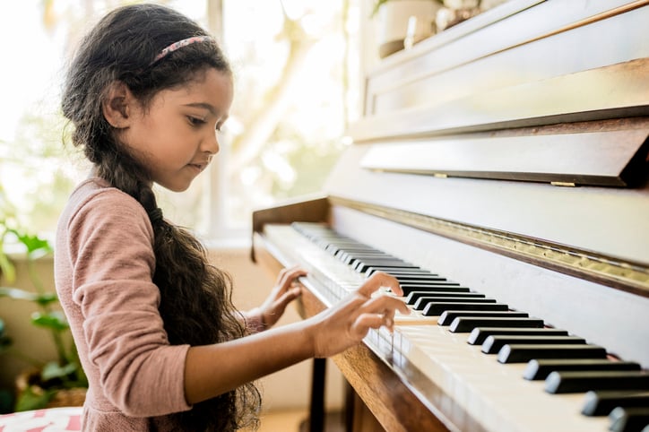 gifted girl with autism playing the piano