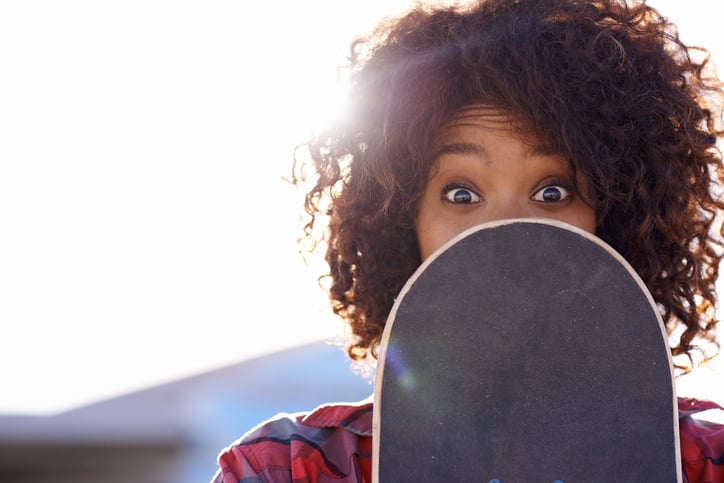 girl-hiding-behind-skateboard