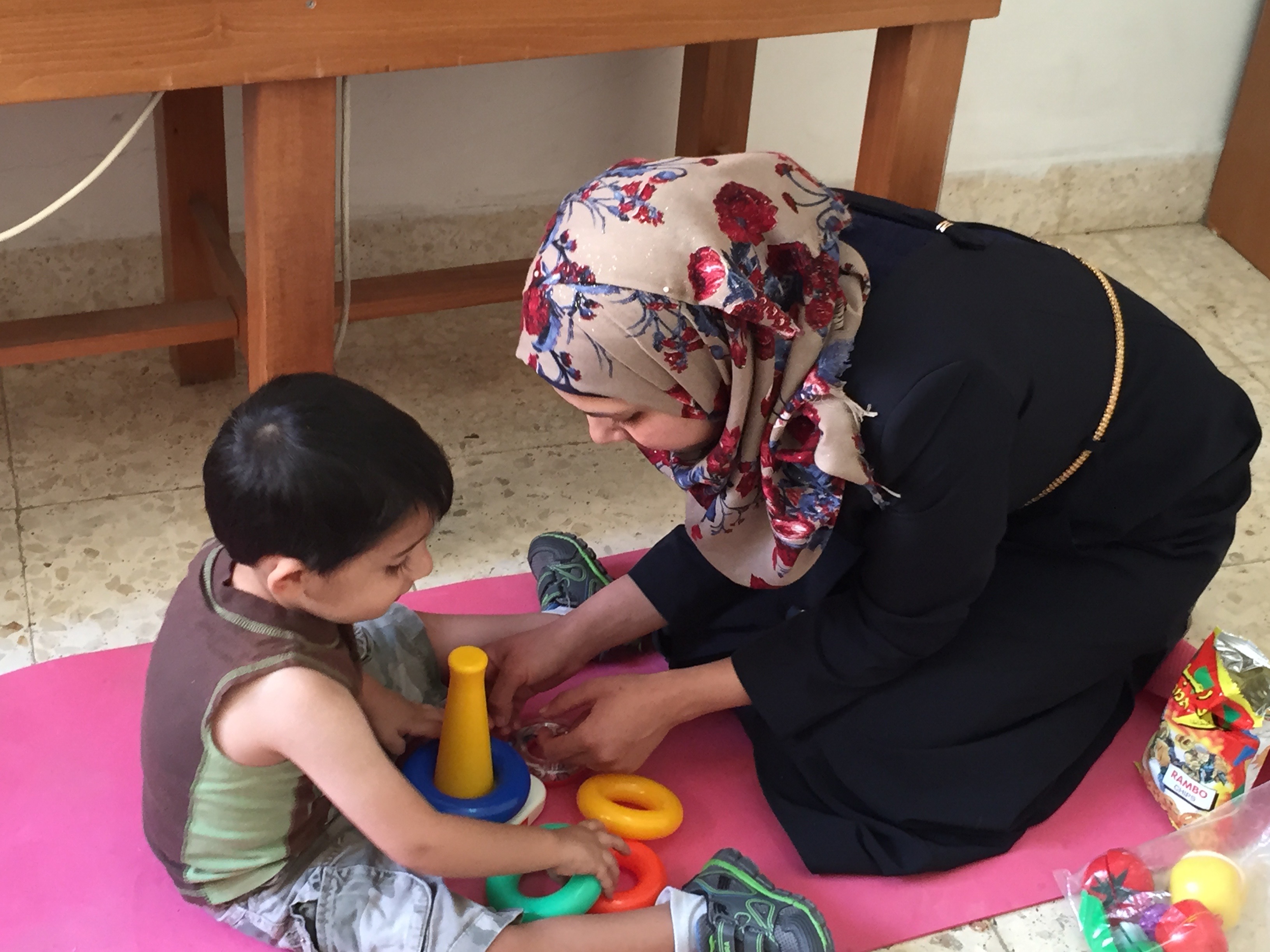 mother helping son with autism-play a game
