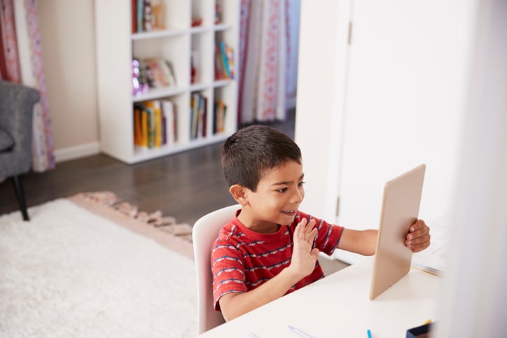child-waving-to-therapist-through-technological-device
