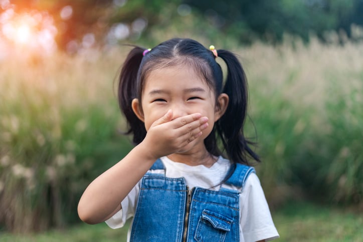 girl-practicing-whole-body-listening-by-placing-hand-over-mouth
