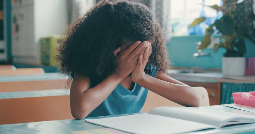 girl with autism crying during school worksheet
