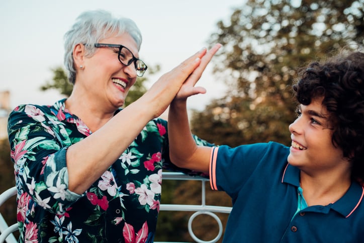 grandmother and grandson with autism high fiving