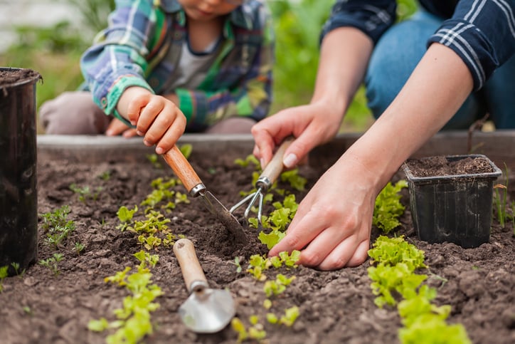 parent and child with autism planting a garden