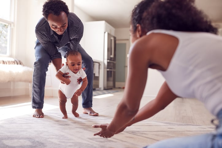 parents encouraging their child to walk