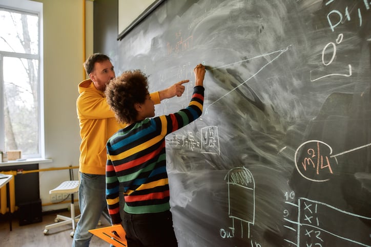 young boy with autism with IEP working with a teacher