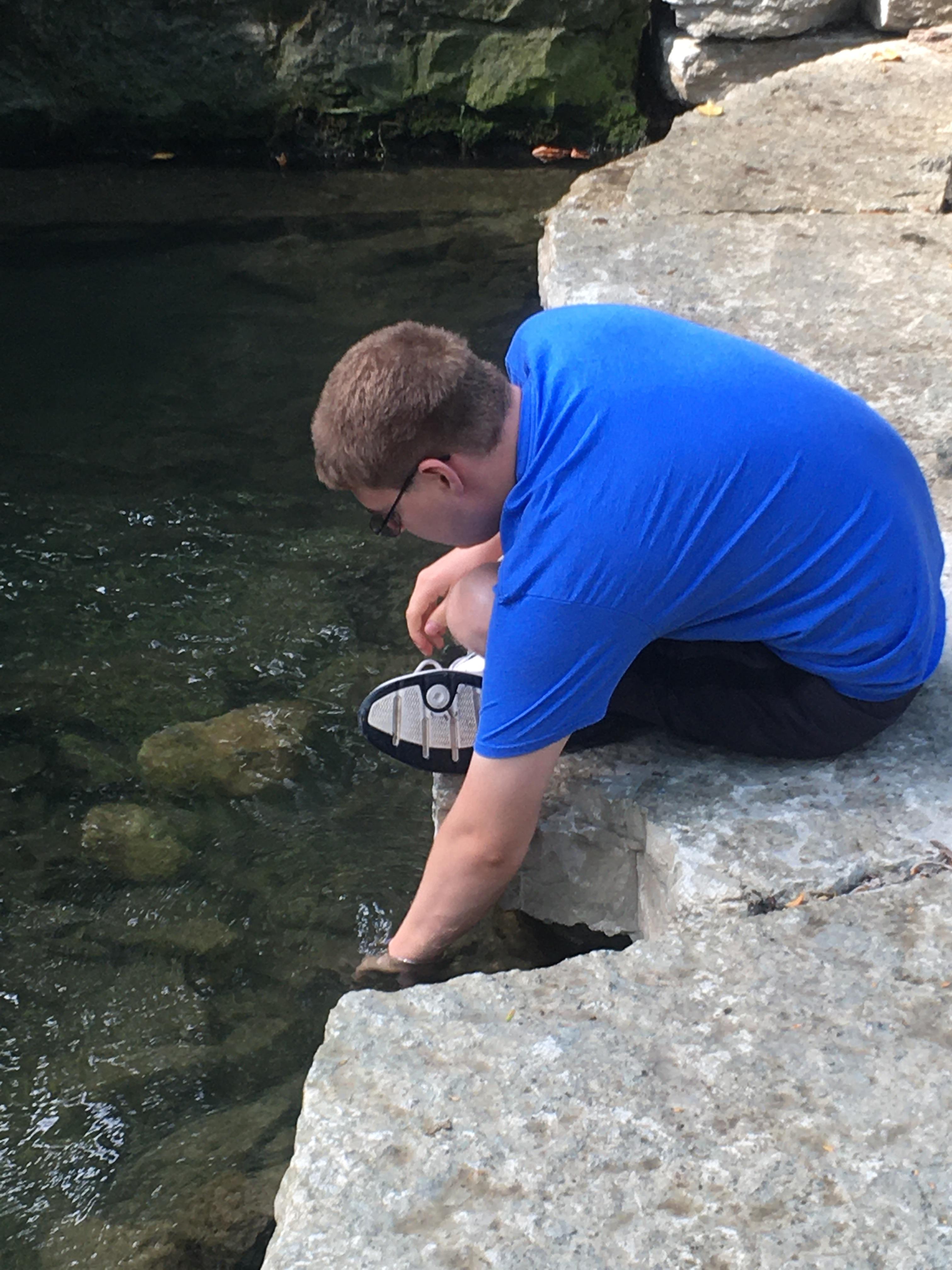 jim-at-creek-putting-hand-in-water