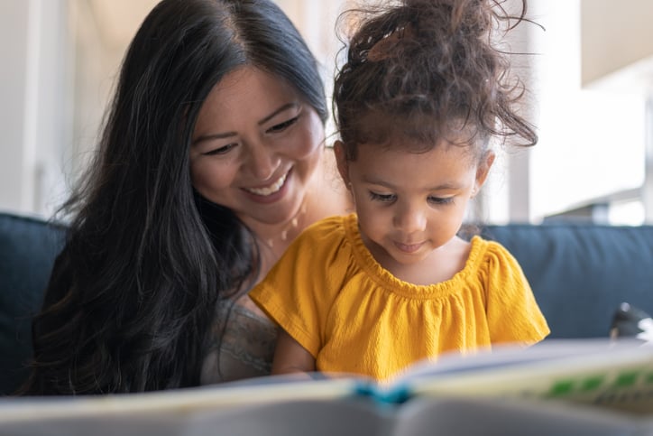 mother and daughter with autism reading book together