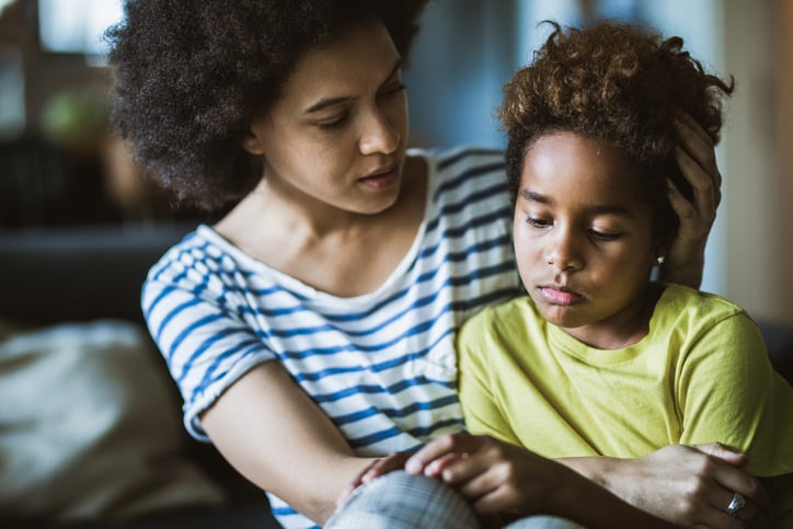 mother taking care of her depressed little daughter with autism at home.