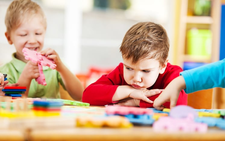 Small angry boy with autism looking at the toys.