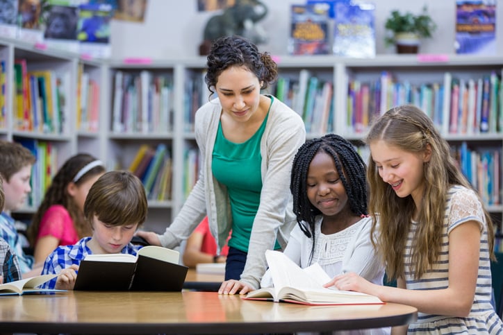 teacher working with students in inclusion classroom
