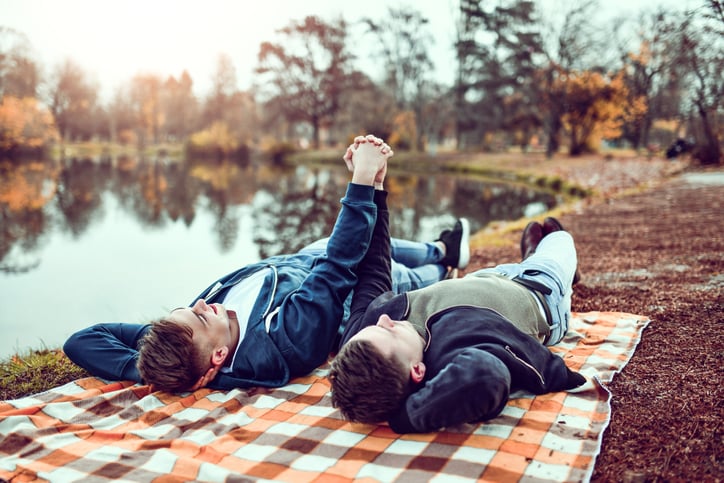 two boys holding hands on a picnic autism