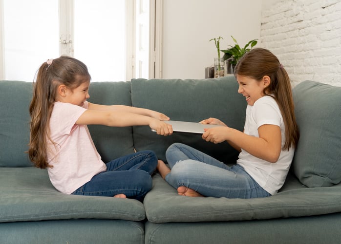 two children with autism fighting over a book
